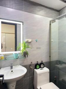 Un baño con inodoro, lavabo y espejo. en Four P Home Phu Nhuan, en Ho Chi Minh