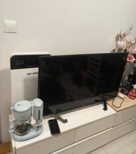 a large flat screen tv sitting on top of a dresser at Mickey home's in Ho Chi Minh City