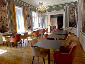 a restaurant with tables and chairs and a chandelier at Domaine de la Tremblère in Arthon +33 photos