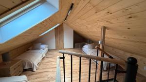a attic room with two beds and a staircase at Jeleń Residence in Jeleniów