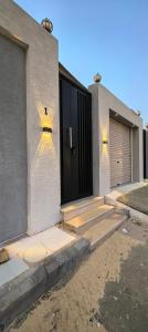 a house with a black door and some stairs at Najd1 in Al Hofuf