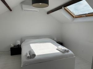 a white bedroom with a bed and a window at Maison Mont Valérien Spacious Family and Business Stay with AC and Parking, near Paris La Défense in Nanterre +27 photos