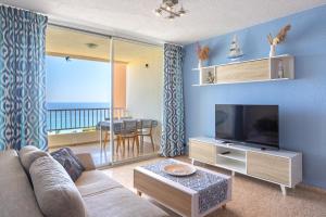 Una sala de estar con un sofá y un televisor de pantalla plana. en Paradise View, en Villajoyosa
