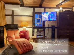a living room with a tv and a chair at Romantische und museal eingerichtete Ferienwohnung in Stein