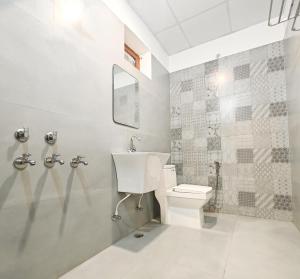 a bathroom with a toilet and a sink at A2 Villa by JMD - Peaceful Stay Near Expo Mart in Greater Noida