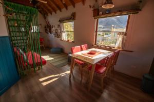 a dining room with a table and red chairs at CasaAndina Chalten in El Chalten