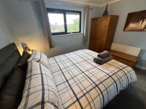a bedroom with a bed with a suitcase on it at Superb Comfy 2 Bed House, Responsive & Caring Hosts Free WiFi & Parking, Close to MK Centre, Train Station, Santander, Network Rail by Webbhill Stays in Milton Keynes