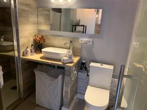 a bathroom with a sink and a toilet and a mirror at Apartamento con encanto Manchigon in Palomares del Río +32 photos