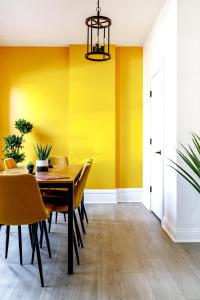 una sala da pranzo con pareti gialle, tavolo e sedie di Short North Convention King Bed Free Parking! a Columbus