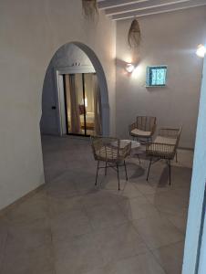 a room with a table and chairs and an archway at Magnifique villa typique avec piscine privée in El Guecheïne