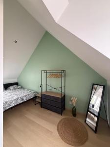 Un dormitorio con una cama y un espejo en un ático. en Appartement vue sur le vieux port de Pornic, en Pornic