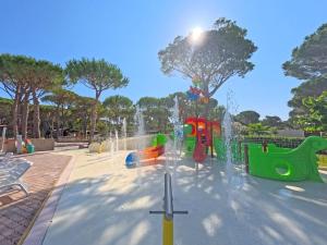 a playground with a fountain in a park at Campeggio del Forte in Marina di Bibbona