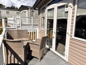 a porch with two chairs and an open door at The coast retreat - 14 wood farm in Charmouth