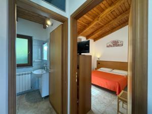 a bedroom with a bed and a bathroom with a sink at Villa Rosi&Maria in Coccorino