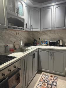 a kitchen with white cabinets and a sink at Cozy apartment in Haskovo +7 photos