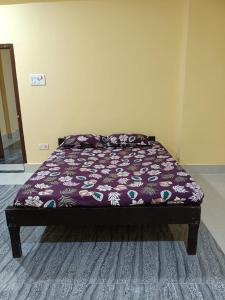 a bed with a purple comforter in a bedroom at Mns residency in Imphal