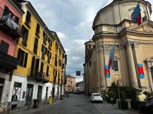 Un coche blanco circulando por una calle al lado de un edificio. en Casa del Mercante in centro ad Asti no ztl, en Asti