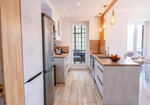 a kitchen with a refrigerator and wooden floors at Le Clos des Poncétys - gîte de charme avec piscine dans les vignes de Bourgogne in Davayé