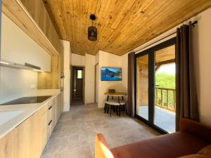 a kitchen with wooden ceilings and a dining room with a table at CAP PARADISU - Chalet vue mer et montagne in Santa-Maria-di-Lota