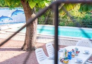 a table and chairs in front of a tree at Le Clos Poncétys - Villa avec Piscine in Davayé