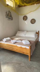 a bedroom with a wooden bed with towels on it at Syrma Sunset Areti in Kástron