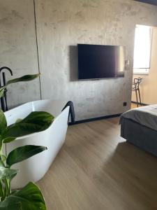a bathroom with a bath tub and a tv on a wall at Apartament Imperial Przedmieście in Grudziądz