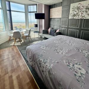 a bedroom with a bed and a table and chairs at On The Beach Apartments in Blackpool