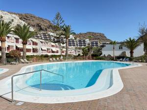 a large swimming pool with palm trees and buildings at Mar de Luna in Puerto Rico de Gran Canaria