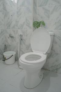 baño blanco con aseo y planta en Dayon place near the airport, en Puerto Princesa City