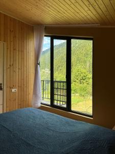 a bedroom with a bed and a large window at Khedi Utsera in Utsera
