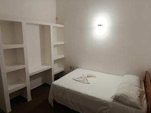 a bedroom with a bed with white shelves at Hotel Begrand Tapachula in Tapachula