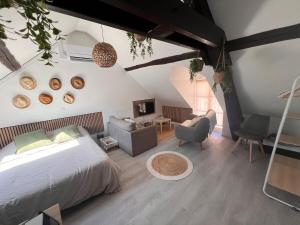 a bedroom with a bed and a couch and a chair at Studio moderne Plein Centre Nemours in Nemours