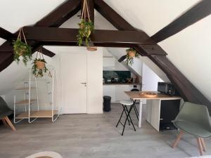 an attic room with a table and a kitchen at Studio moderne Plein Centre Nemours in Nemours +12 photos
