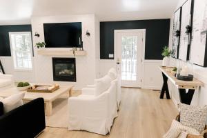 a living room with white furniture and a fireplace at Oak & Ember Lodge in Mount Jackson