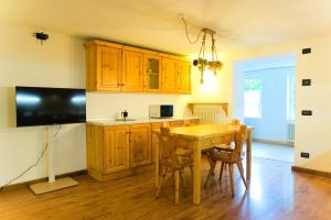 Una cocina con gabinetes de madera y una mesa de madera. en Dolomiti Garden Flat, en Villanova 17 fotos más