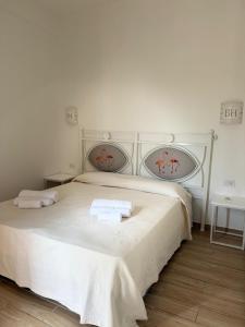 a bedroom with a white bed with two towels on it at Hotel Majore in Santa Teresa Gallura