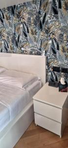 ein Schlafzimmer mit einem Bett und einer Kommode und einer Tapete in der Unterkunft Ca' Zueca in Venedig