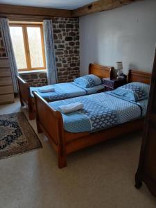 a bedroom with two beds and a window at Le Petit Étang in Passais-la-Conception