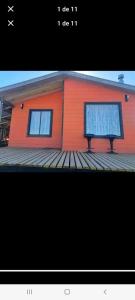 a house with two windows on a wooden deck at Cabañas almendra in Quellón