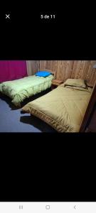 two beds sitting next to each other in a room at Cabañas almendra in Quellón +3 photos