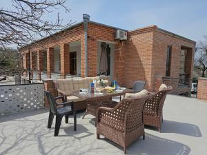 a patio with a table and chairs and a building at Kera in Dedoplis Tskaro