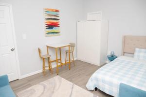 Un dormitorio con una cama y una mesa y sillas. en Brighton Beach Retreat Blue30, en Brooklyn