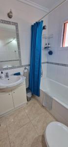 a bathroom with a blue shower curtain and a sink at Tres Playas Apartment in Puerto de Mazarrón