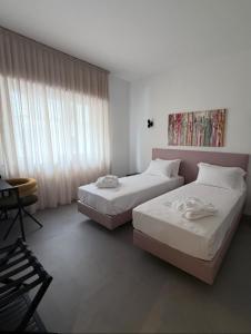 Un dormitorio con dos camas y una silla. en DoorMI - Premium Suites and Apartments, en Milán