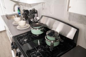 2 ollas y sartenes en una cocina en Brighton Beach Retreat Blue30, en Brooklyn