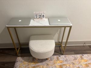 a desk with two laptops and a chair with a clock at LUX Apt 2 Min to TCU Pool & Gym! in Fort Worth +20 photos