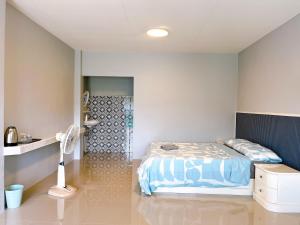 a bedroom with a bed and a shower in it at Wanderlust Homestay Ranong in Ranong