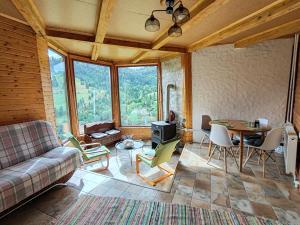 a living room with a couch and a table at Cabana cu hamac in Prisaca Dornei