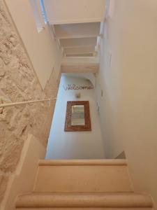een trap in een gebouw met een bord aan de muur bij PugliAlcove in Castellana Grotte