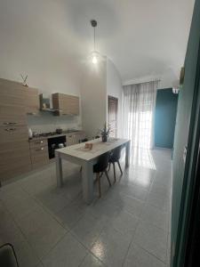 a kitchen with a table and chairs in a room at D'Aversa Rooms in Marineo